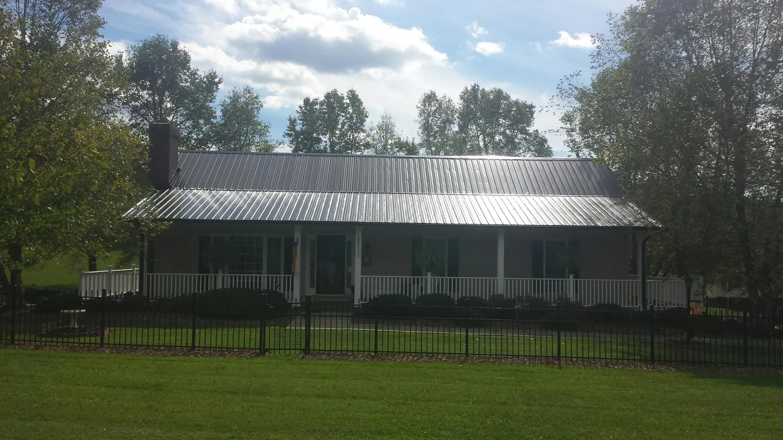 Gray metal roof on a brick ranch with a full width front porch — Gutter Guard Installation work by our crew in Kennesaw