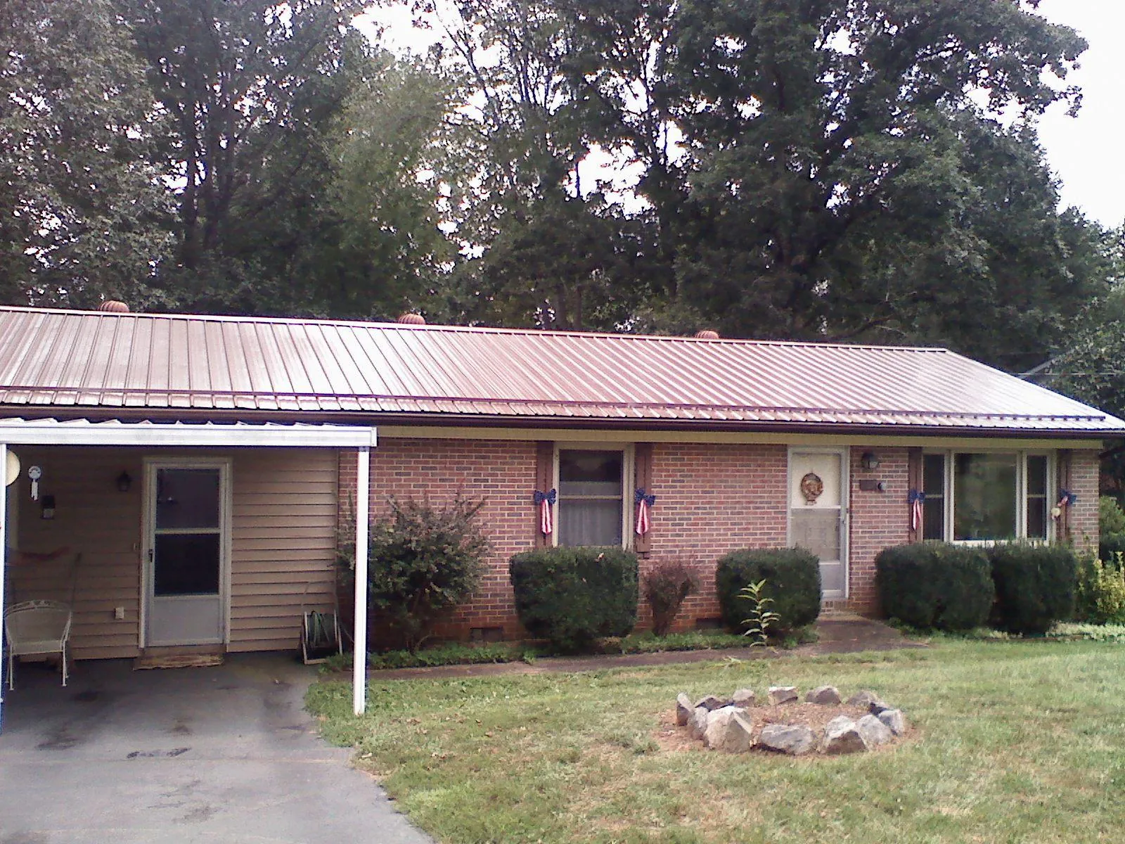 Bronze metal roof and carport on a brick ranch home — Roof Repair work by our crew in Kennesaw